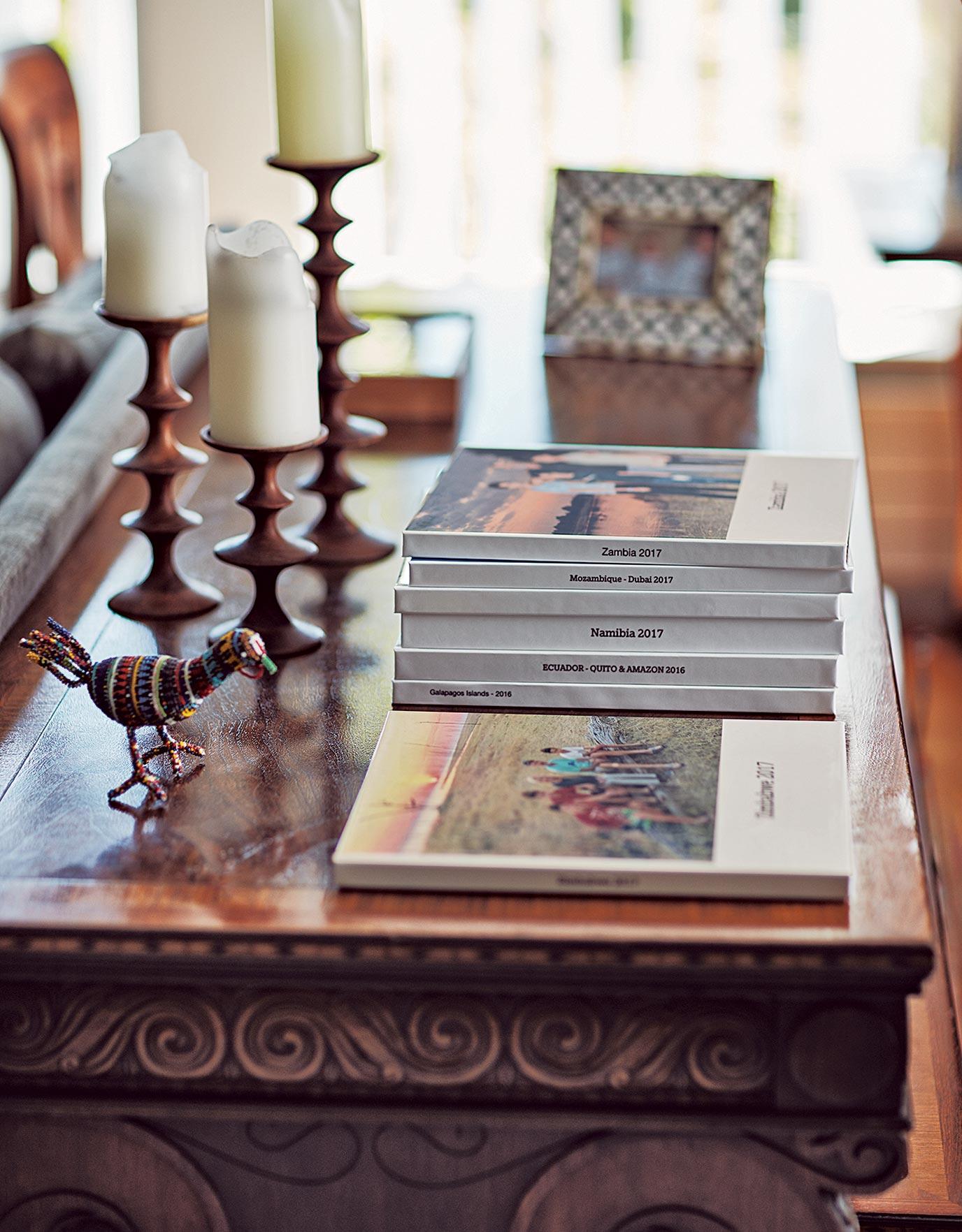 Family photo albums from Kenya, Inda and Zambia adorn a coffee table as seen in California Closets Ideas of Order Magazine