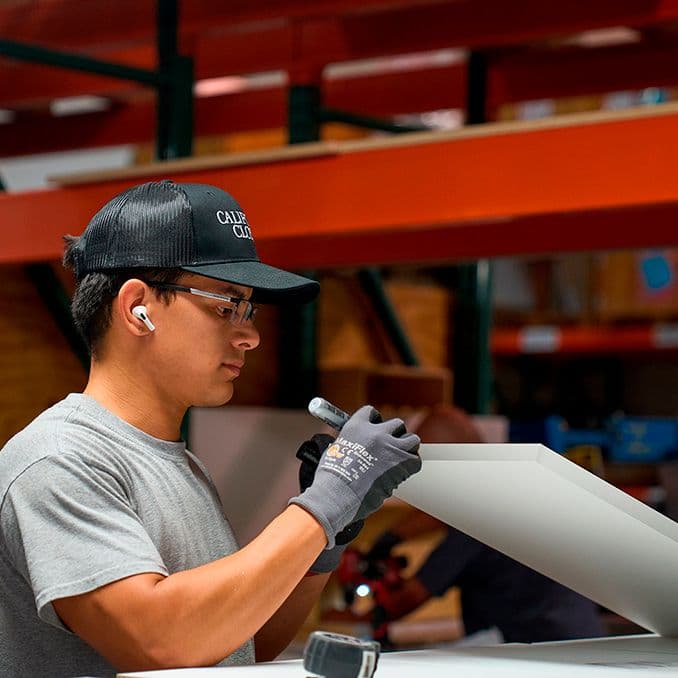 Empleado en la fábrica trabajando con productos de alta calidad para la construcción de armarios de California Closets