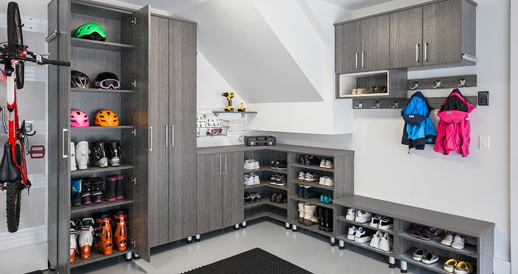 Gabinetes de garaje personalizados con cubículos, repisas para zapatos y almacenamiento para equipo deportivo de California Closets