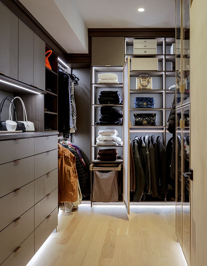 Ashley Graham's walk in closet design with custom built-in dresser, lighted countertops and sweater shelves from California Closets
