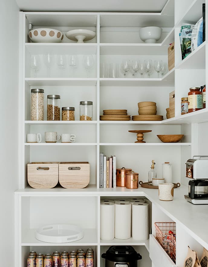 Almacenamiento en despensa con repisas abiertas, perfecto para artículos de cocina y cristalería de California Closets