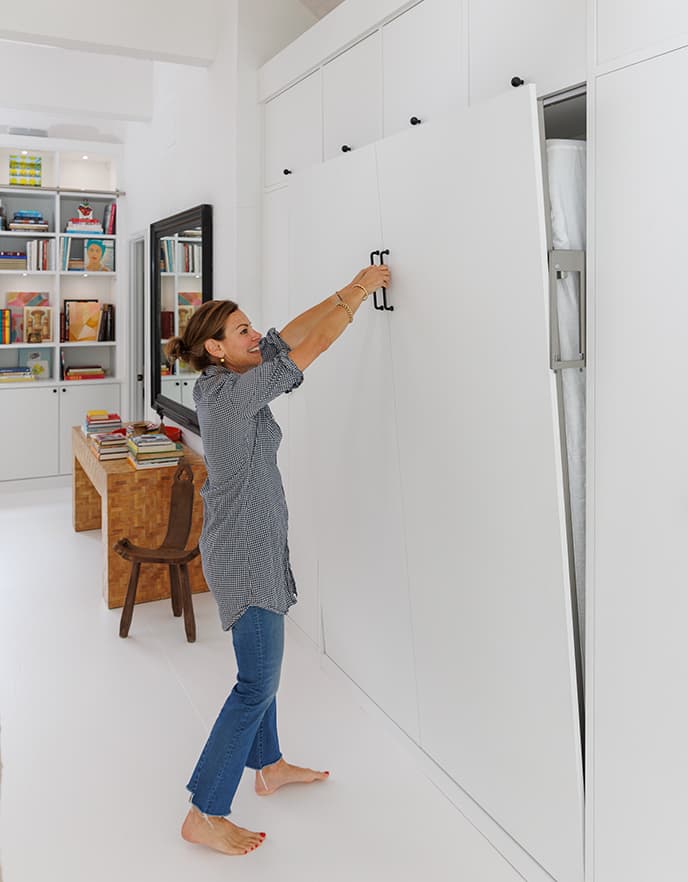 Un estudio de arte también sirve como refugio nocturno para huéspedes, mostrando a Serena Dugan abriendo su cama de pared de California Closets