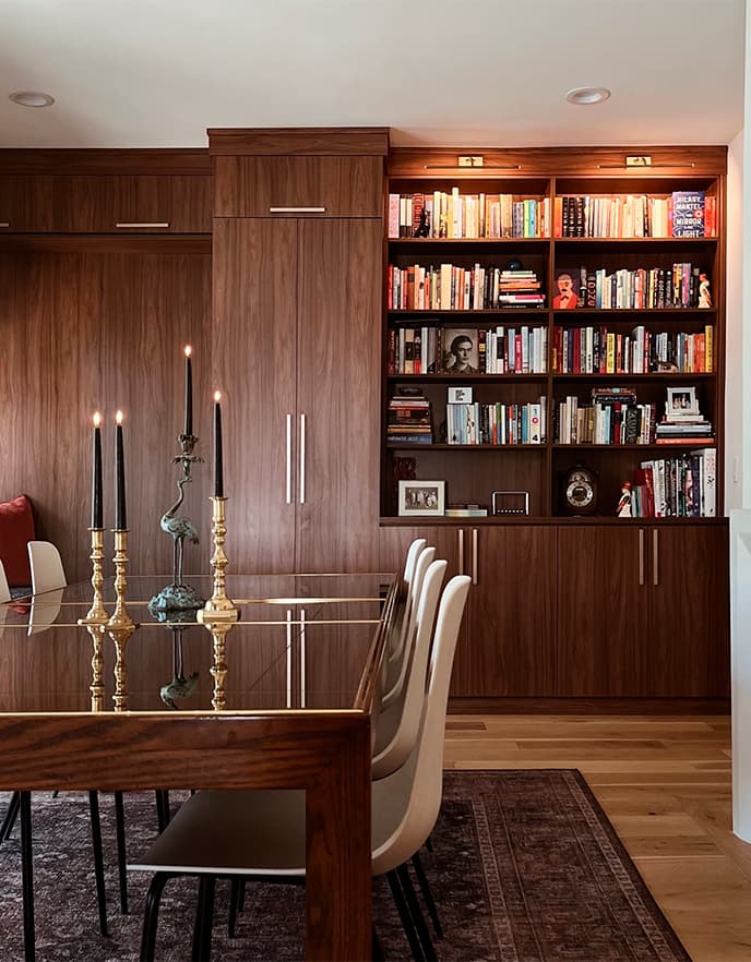 Vista frontal y lateral de repisas personalizadas para biblioteca con acabado en madera oscura y herrajes dorados de California Closets