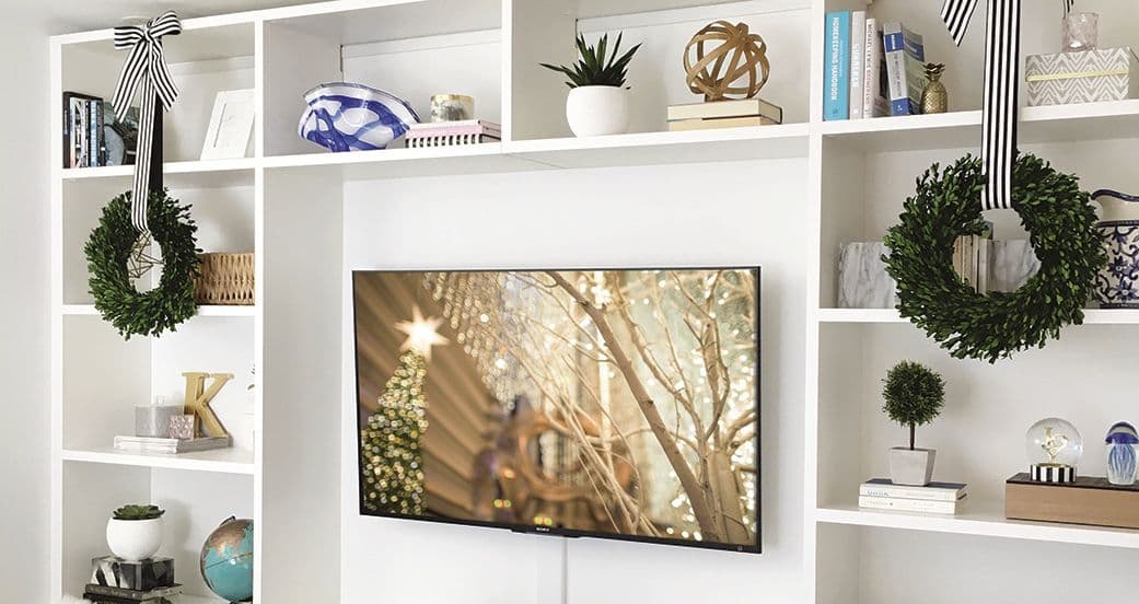 Custom built entertainment center with holiday decor and wreaths from California Closets