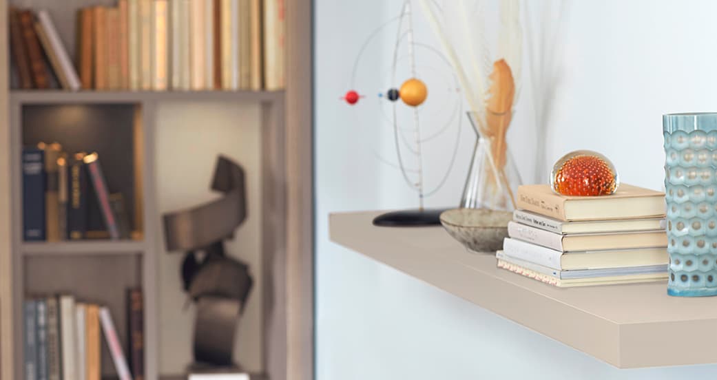 Repisas abiertas junto a espacio de encimera personalizada para una biblioteca personal de California Closets.