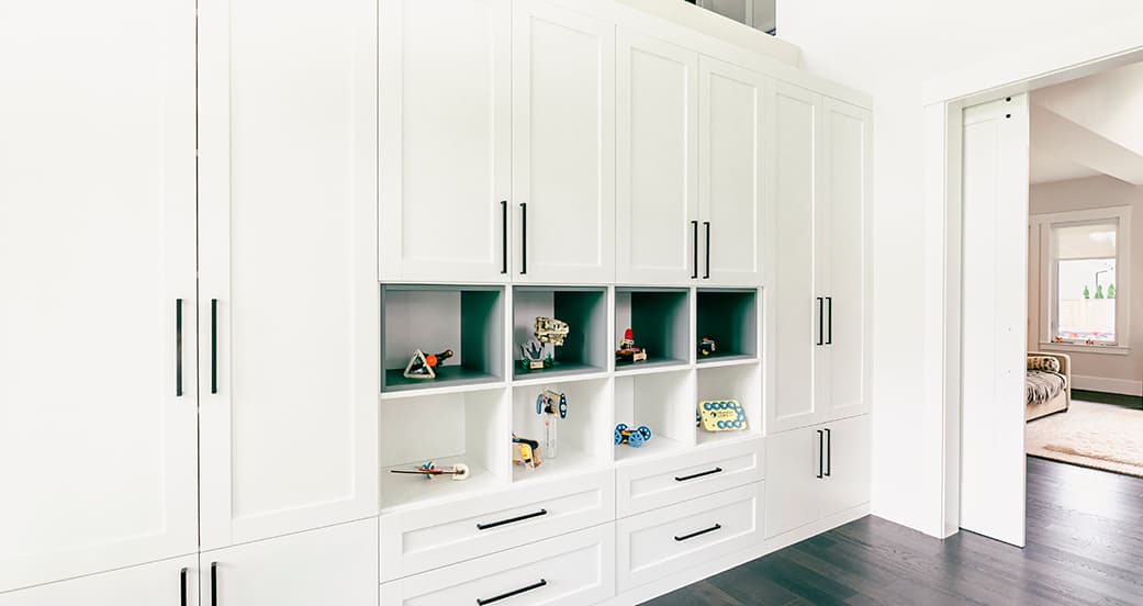 Gabinetes de almacenamiento para juegos y juguetes en una sala de juegos infantil de California Closets.