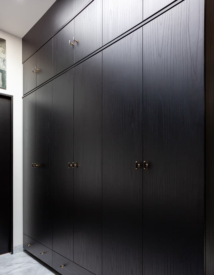 Laundry room design in dark finish with floor to ceiling storage design from California Closets