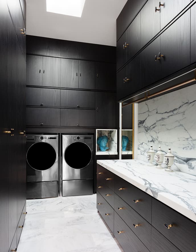 Modern traditional laundry room designed with marble finish counters from California Closets