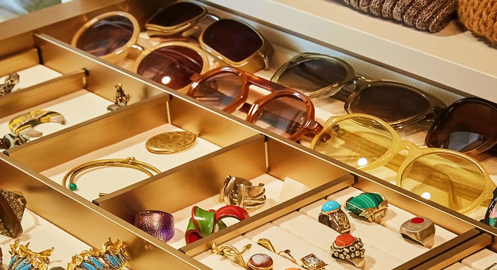 Jewelry accessory drawer separated by gold divider organizers by California Closets