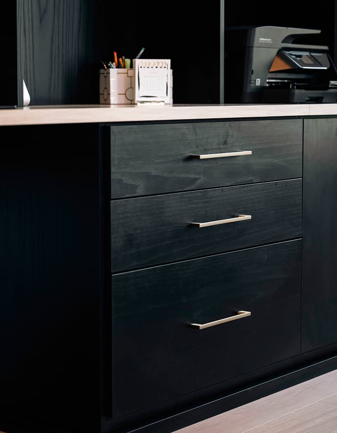 Home office with ample built-in storage, display shelving for books and awards, featuring gold Elite handles