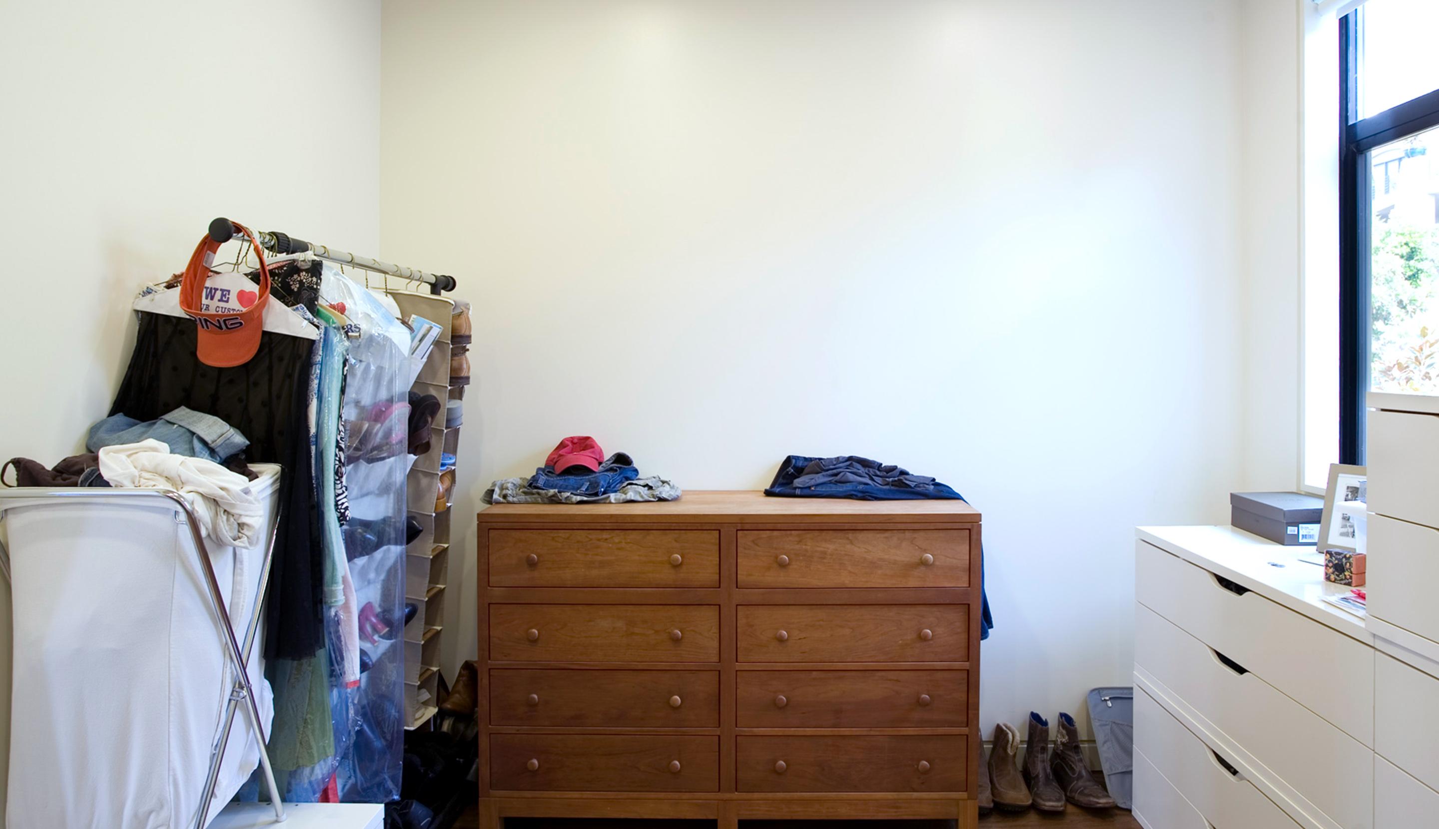 Diseño planificado de clóset tipo walk-in con estantes y barras para colgar antes de la instalación por California Closets