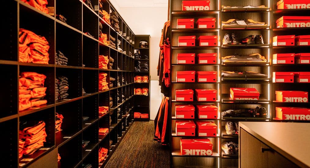Custom athletic locker room storage and professional team apparel shelving designed by California Closets.