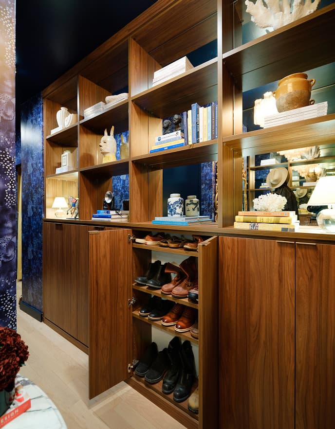 Multifunctional wood display shelving unit and hidden shoe organizer cabinet built by California Closets for a modern hallway layout.