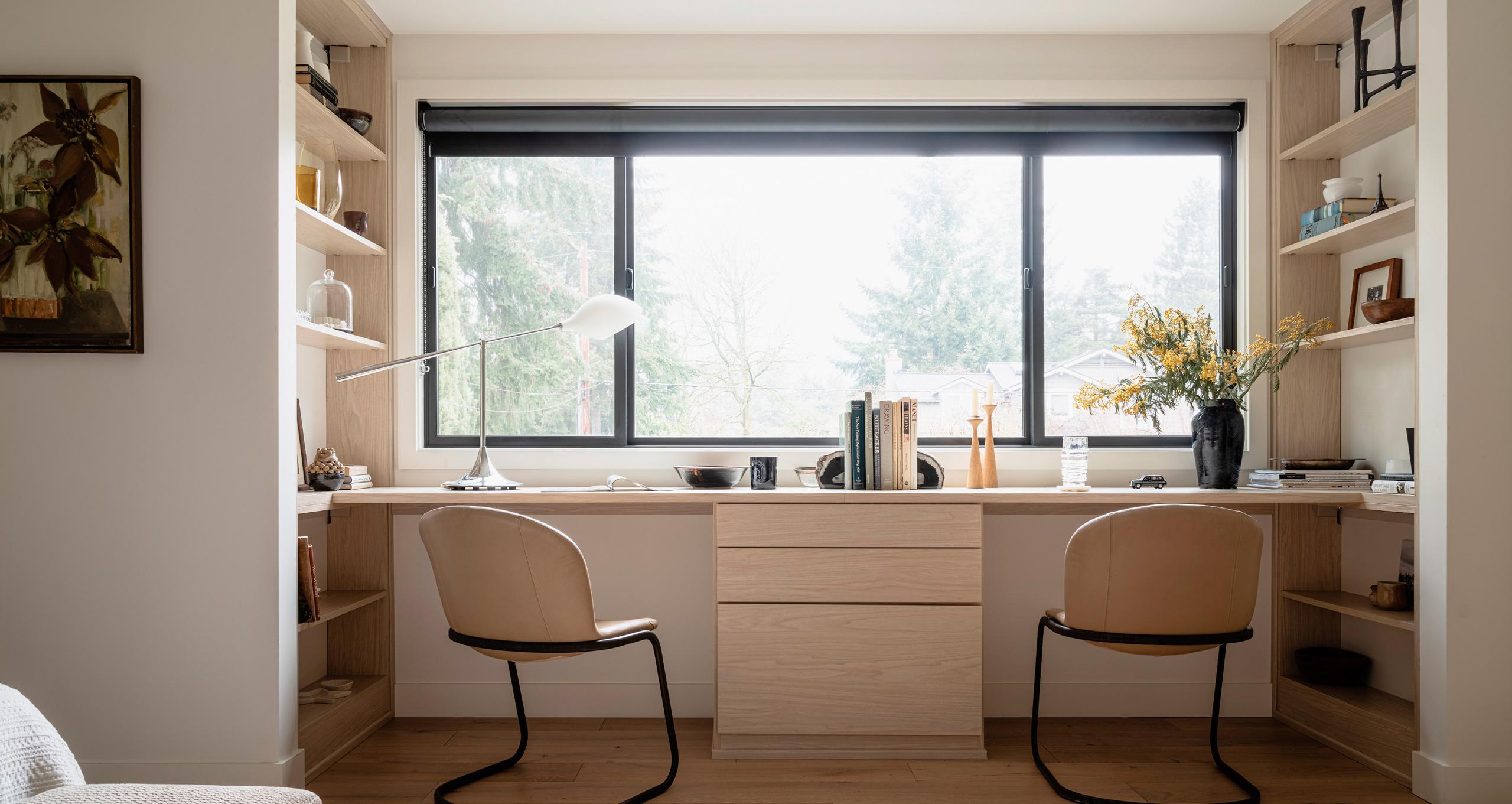 Shared home office design featuring a custom built-in window desk with a central drawer unit and matching bookshelves by California Closets.