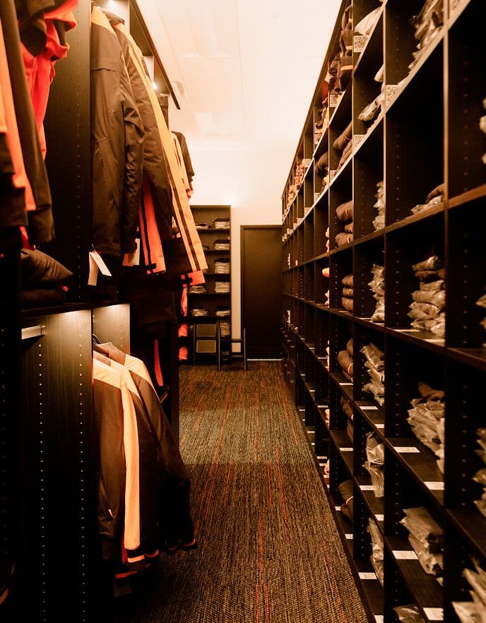Solución personalizada de repisas de almacén comercial y almacenamiento de inventario minorista retroiluminado por California Closets.