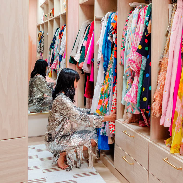 Clóset tipo walk-in bellamente organizado, con cajones que exhiben las soluciones de almacenamiento y la calidad artesanal de California Closets