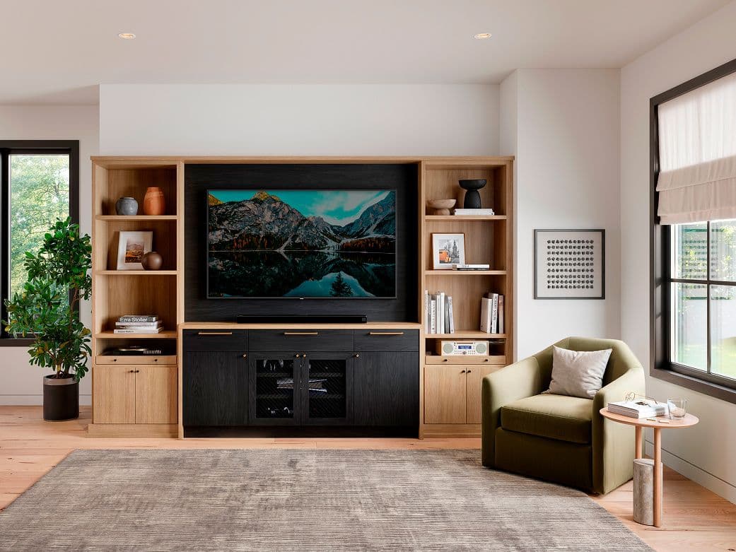 Custom built-in media center by California Closets featuring light wood shelving and a central black TV wall unit.