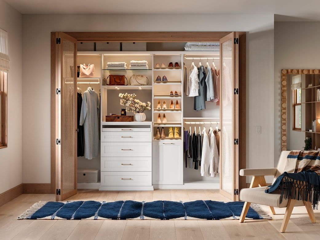Closet con encimera personalizada, iluminación LED, cómoda y cesto de California Closets
