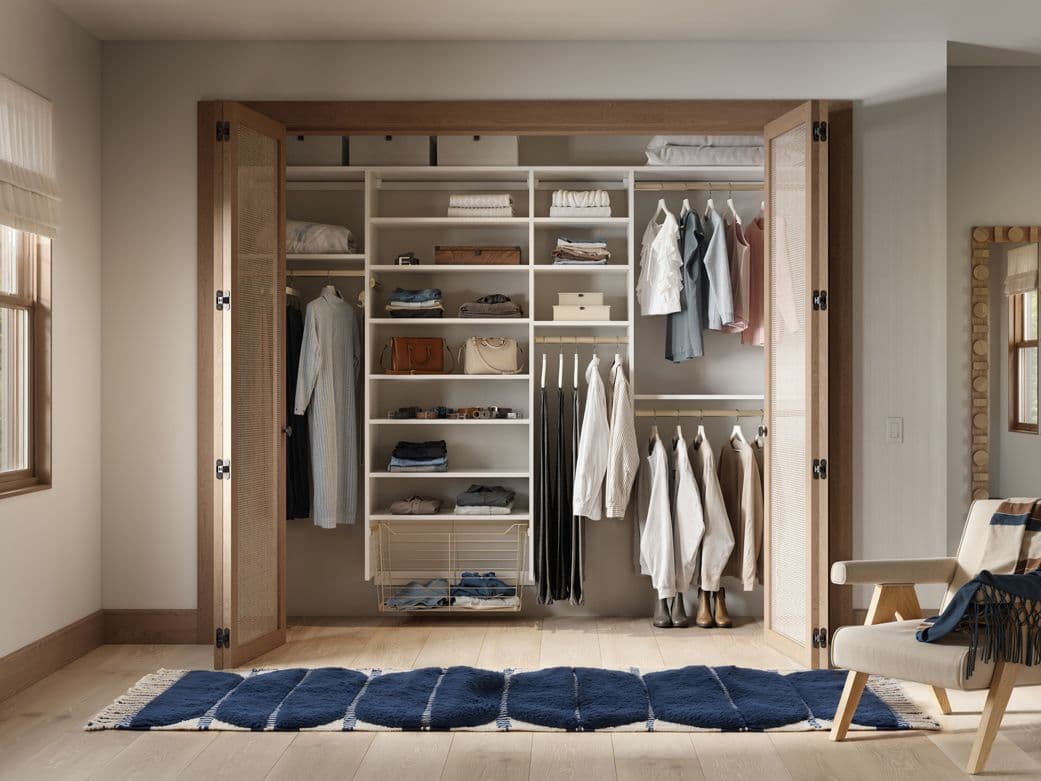 Basic closet layout designed with open shelves and storage baskets by California Closets