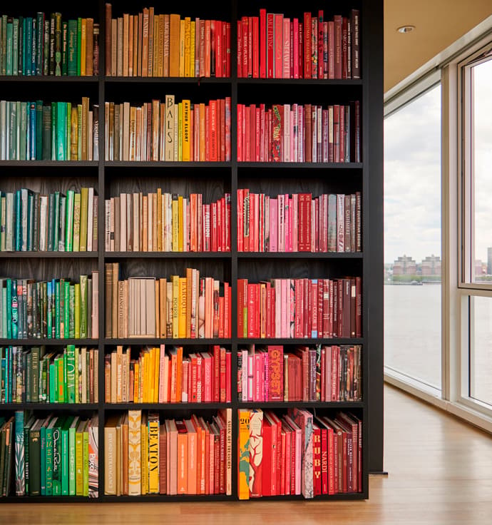 Custom built bookshelves from floor to ceiling in dark wood finish by California Closets