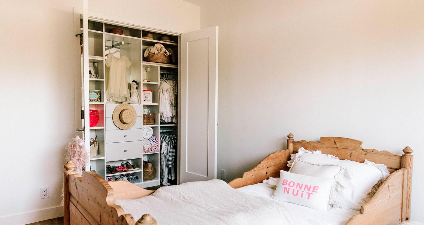 Kid's reach in closet with built in dresser drawers and shelving by California Closets