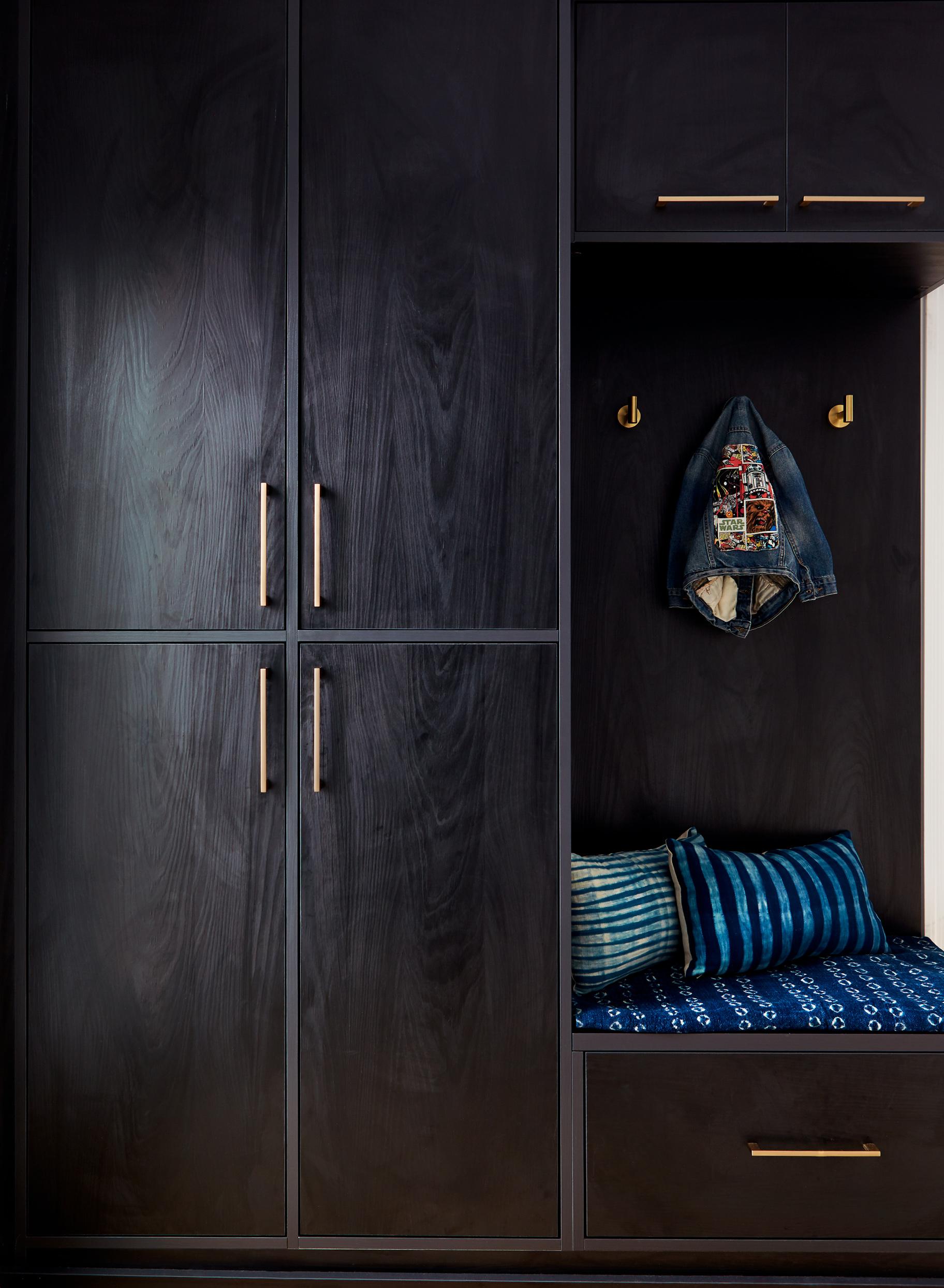 Vestíbulo de entrada personalizado con acabado negro sombra y gabinetes altos de California Closets